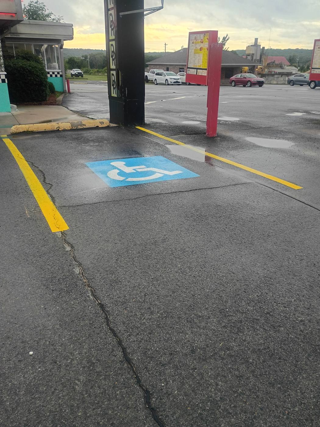 Freshly striped commercial parking lot with crisp yellow lines and ADA-compliant accessible parking symbol